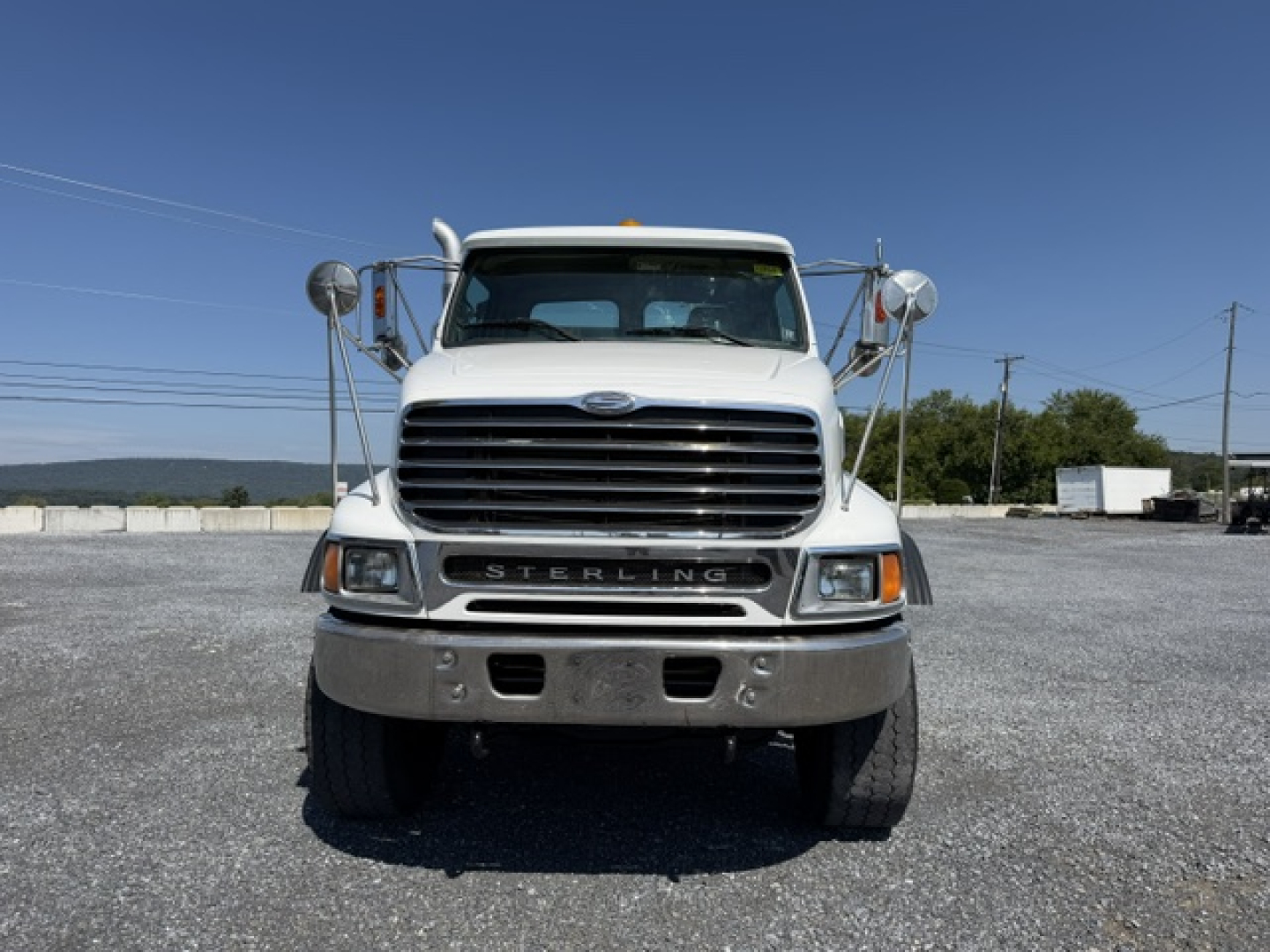 Front view of a white 2006 Sterling LT9500 flatbed truck with large grille and chrome bumper.