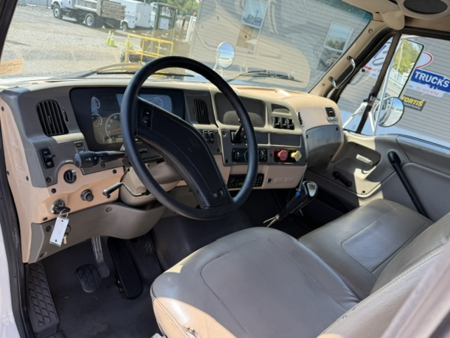 Sterling LT9500 cab interior showing steering wheel, dashboard, and driver seat with beige upholstery.