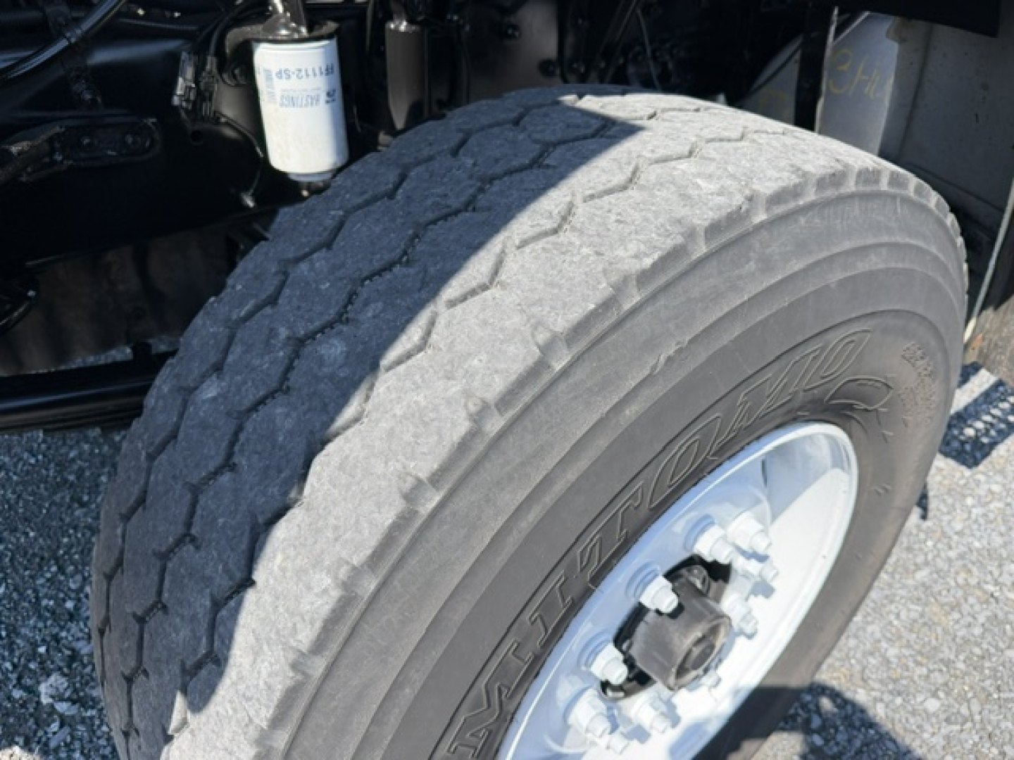 Truck wheel and front suspension assembly showing large front tire, hub, and part of the chassis on a Sterling LT9500 cab-axle.