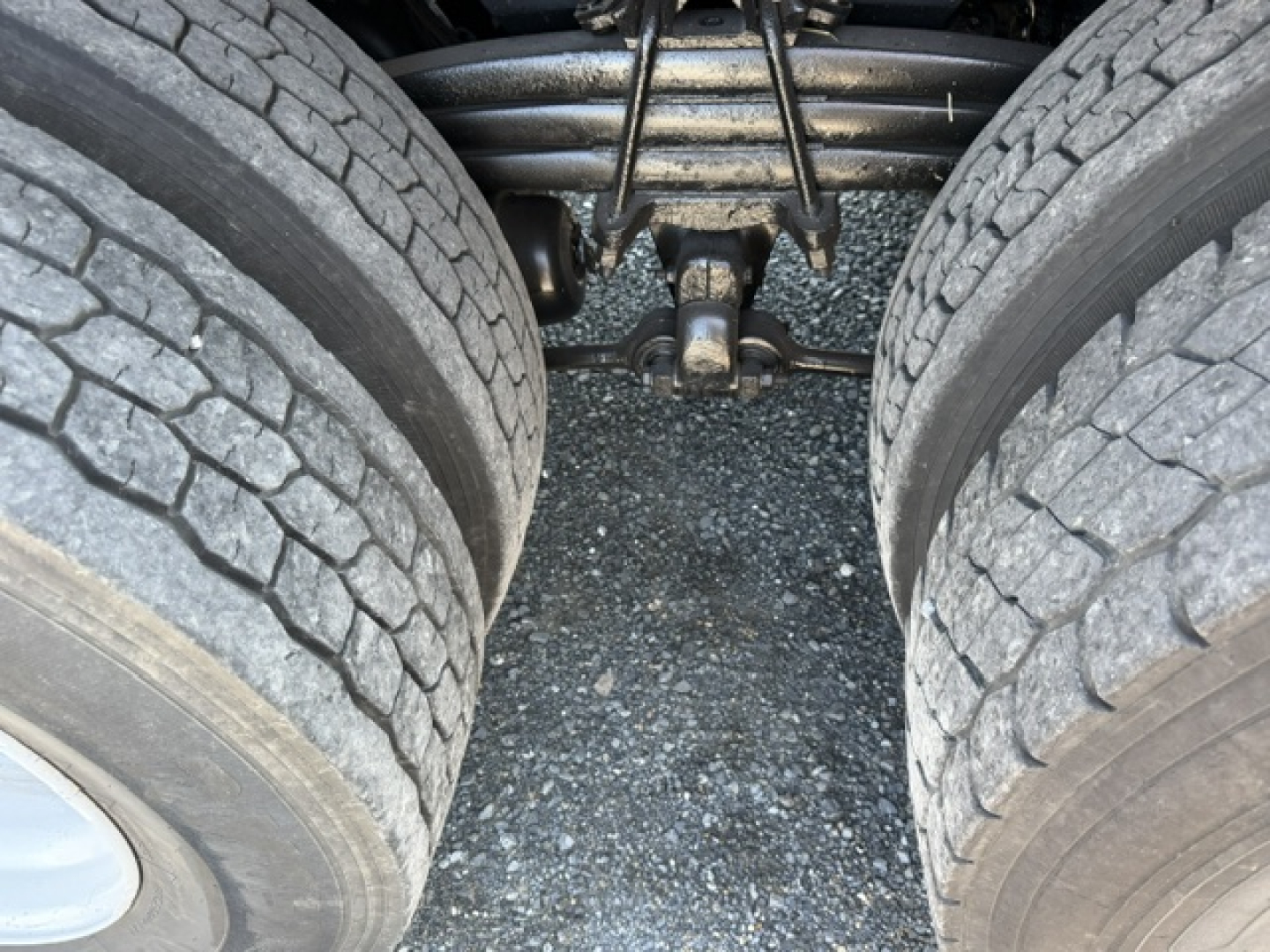 View of Sterling LT9500 rear suspension and dual rear tires with fifth wheel/dreehouse hitch area and drivetrain components visible between tires.