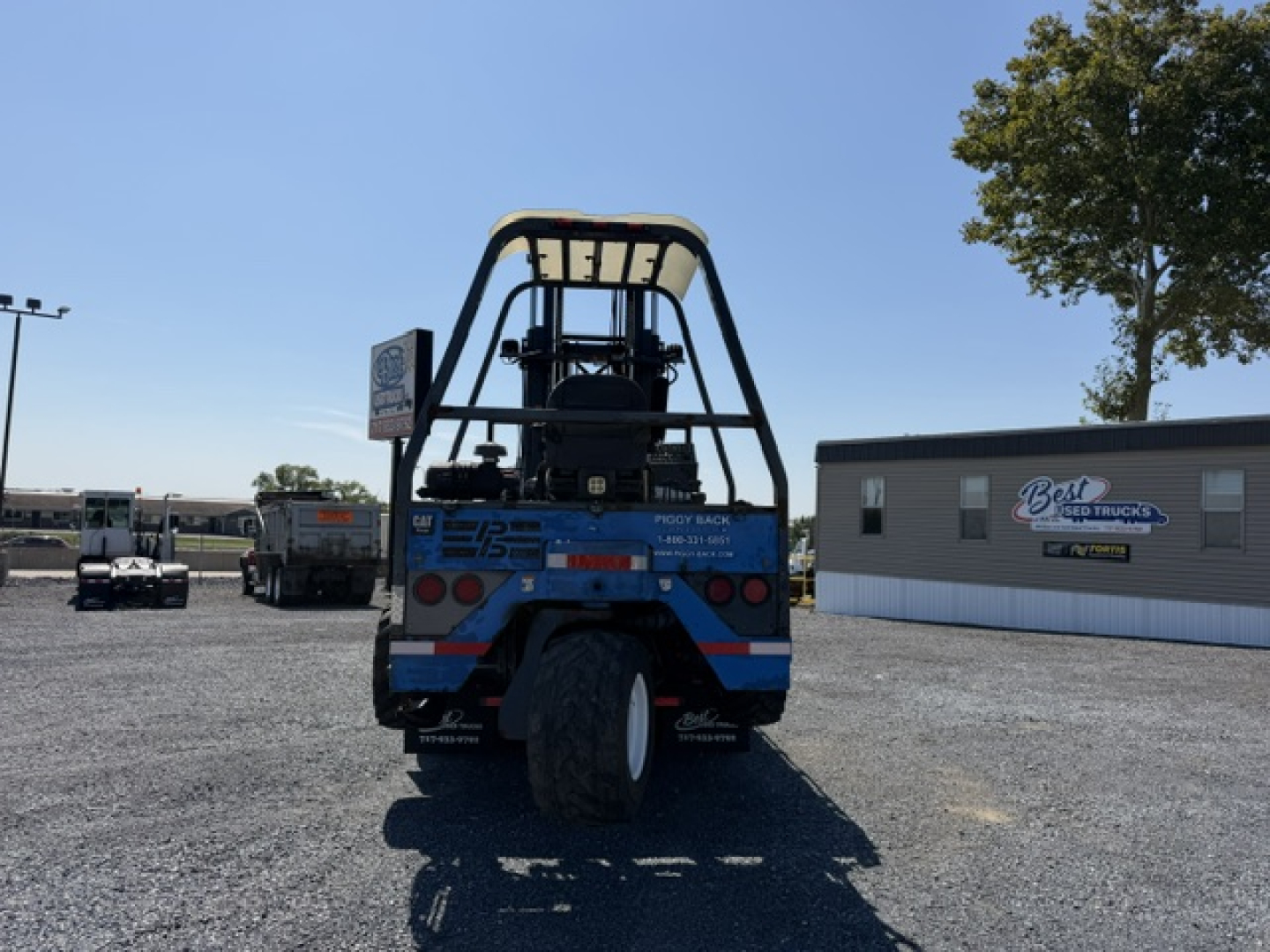 Rear view of a 2006 Sterling LT9500 flatbed truck showing rear bumper, taillights, and spare tire, with a blue/black paint scheme and a roll bar.