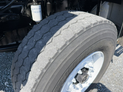 Truck wheel and front suspension assembly showing large front tire, hub, and part of the chassis on a Sterling LT9500 cab-axle.