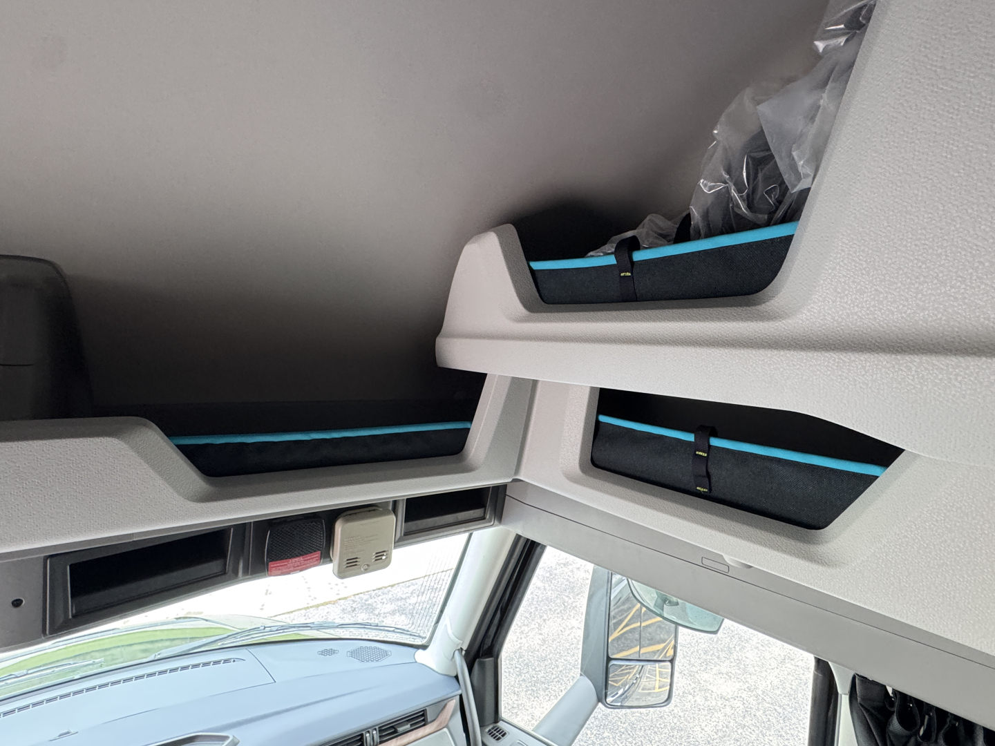 Interior overhead sleeper area of a Volvo VNL truck showing storage compartments and light gray panels.
