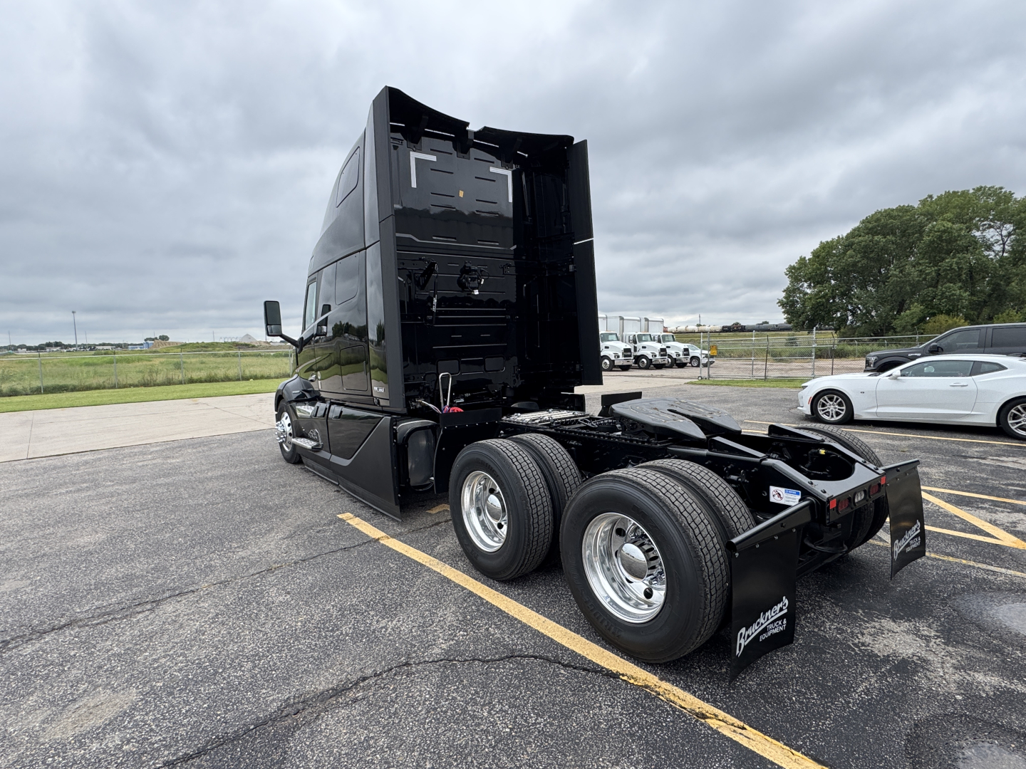 Volvo VNL64T860 tractor rear view showing fifth wheel, dual rear axles, and black sleeper cab with open rear deck; no visible text on components.