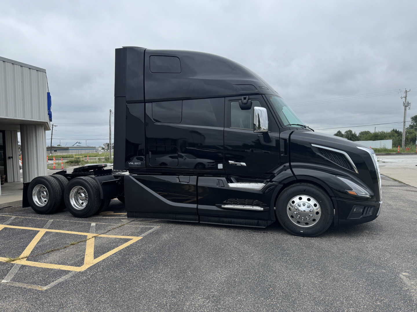 Volvo VNL64T860 semi tractor in black, side profile view, single sleeper cab, with chrome wheels and twin rear axles.