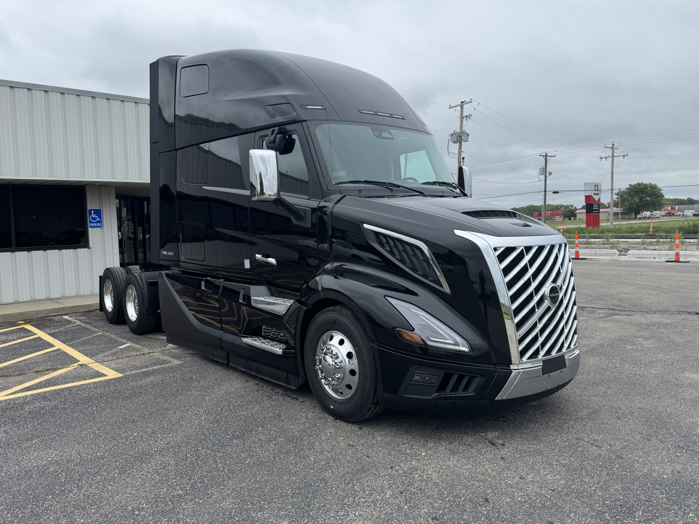 Volvo VNL64T860 truck in black exterior with chrome grille and Sleeper cab, front view showing aerodynamic mirrors and headlights.
