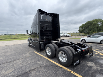 Volvo VNL64T860 tractor rear view showing fifth wheel, dual rear axles, and black sleeper cab with open rear deck; no visible text on components.