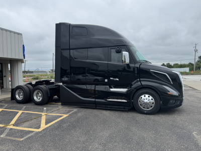 Volvo VNL64T860 semi tractor in black, side profile view, single sleeper cab, with chrome wheels and twin rear axles.