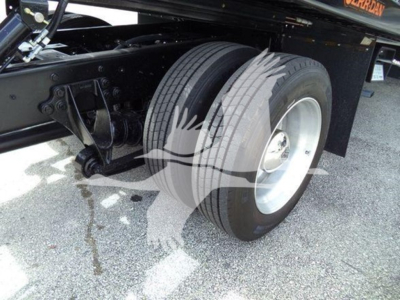Truck rear axle and dual rear wheels of a 2019 International Durastar rollback truck showing dual tires and black chassis.