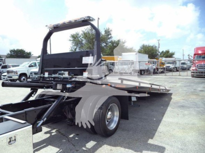 Truck bed rollback equipment on International Durastar 2019 chassis showing flatbed and rear wheels.
