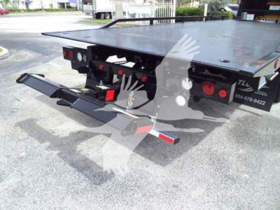 Tow truck platform rear with hydraulic rollback bed and twin rear bumper arms, rear lights visible.