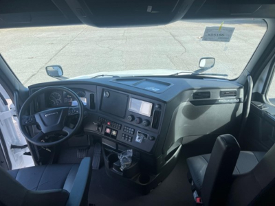 Freightliner Cascadia truck interior showing steering wheel, driver dashboard with gauges, center console, and dashboard controls.