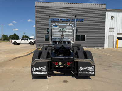 Truck rear view of 2019 Mack PI64T tractor showing dual rear axles, black chassis, metal grab bars, mud flaps with Buc kner's Oklahoma City branding, and a diamond plate headache rack.