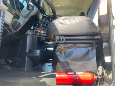 Cab interior of a 2019 Mack PI64T daycab showing driver seat and dashboard with control switches and steering column