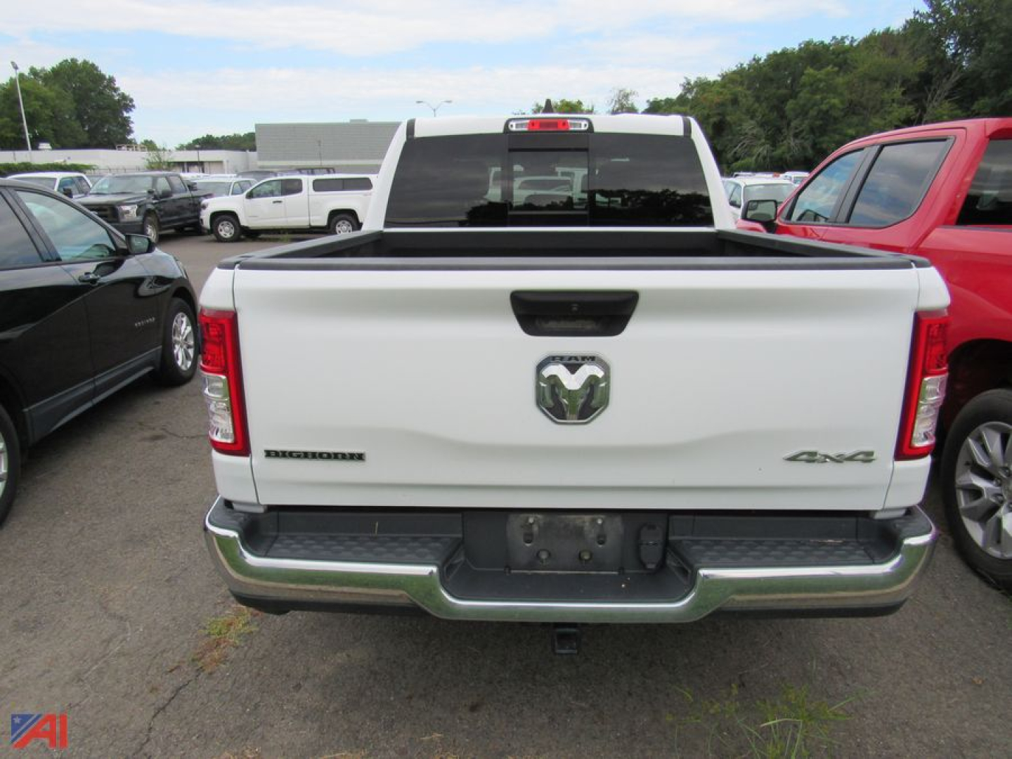 Ram 1500 pickup truck rear view showing 4x4 badge and RAM emblem on tailgate in a used vehicle lot