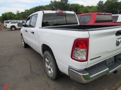 Ram 1500 pickup truck rear-left view in white with bed cover and chrome bumper.