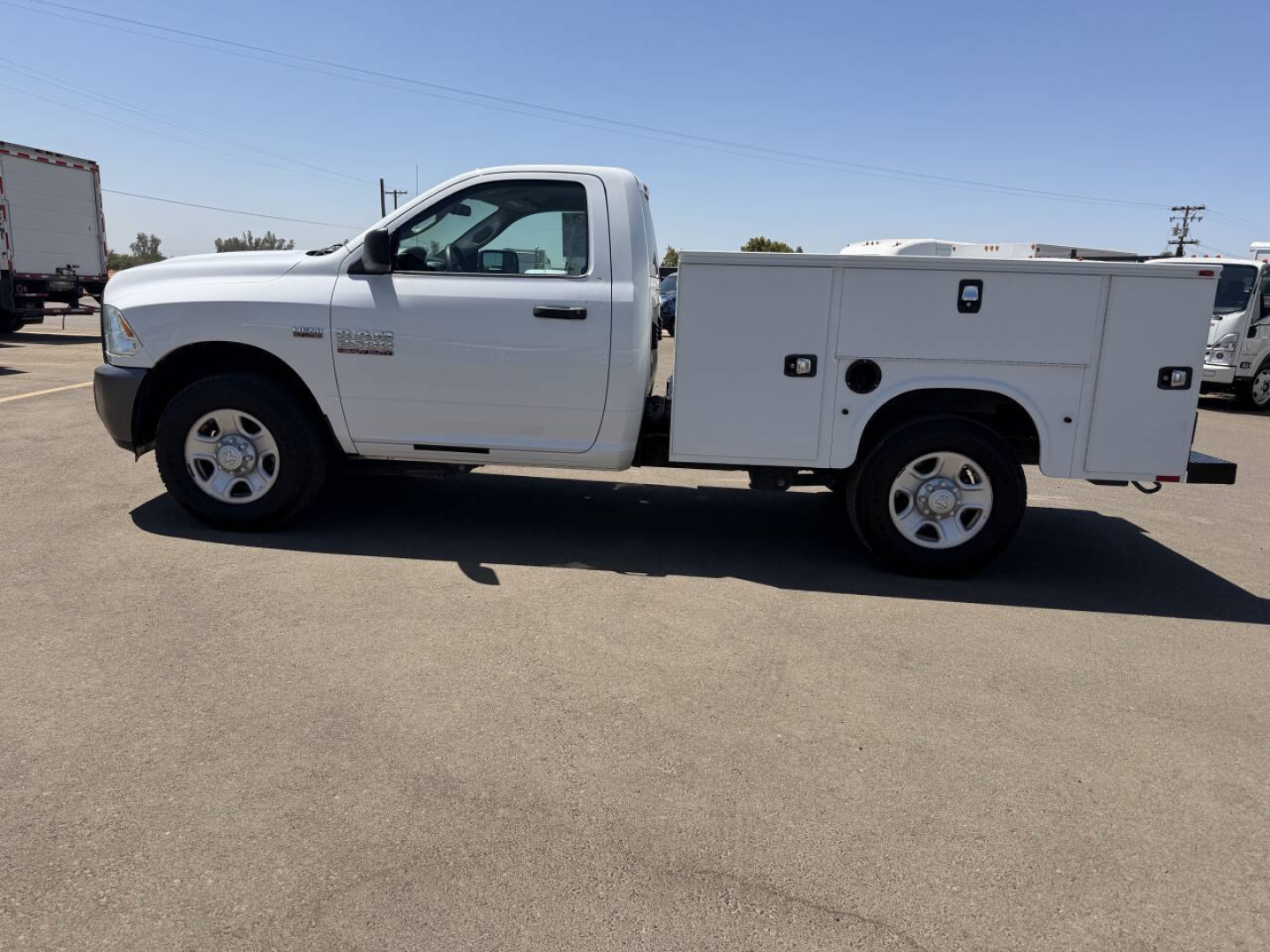 Ram 2500 service body truck side view showing white utility bed and crew cab with stock number 7911.