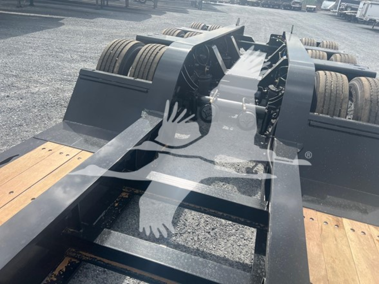 Trailer chassis deck and wheel axles of a Fontaine lowboy trailer showing heavy steel frame and dual rear axles, with wooden loading deck visible.