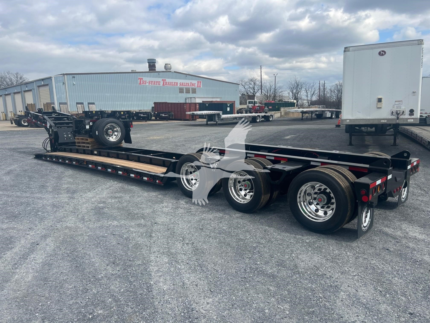 Lowboy trailer with three axles showing Fontaine Magnitude 55H-DSR model details and wheel assemblies.