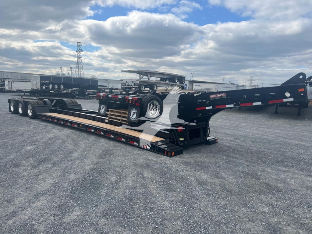 Fontaine Magnitude 55H-Dsr lowboy trailer showing extended gooseneck and deck with multiple axles. Visible stickers and hydraulic components.