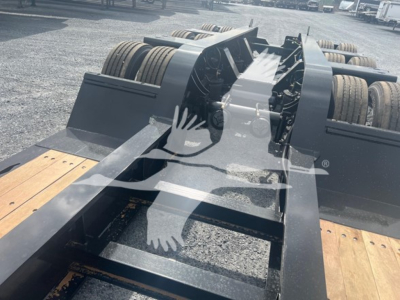 Trailer chassis deck and wheel axles of a Fontaine lowboy trailer showing heavy steel frame and dual rear axles, with wooden loading deck visible.