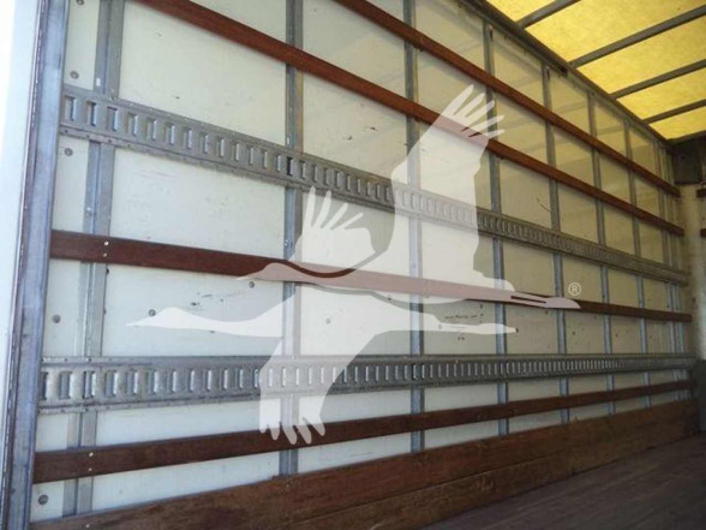 Isuzu NPR HD cargo box truck interior side wall with metal rails and wooden floor, stock image overlay watermark.