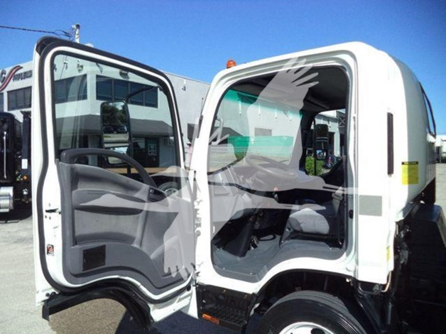 Isuzu NPR HD cab interior view with doors open showing driver and passenger seats and dashboard.