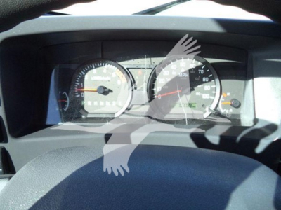 Dashboard of a 2019 Isuzu NPR-HD showing analog gauges including speedometer and tachometer with steering wheel in foreground.