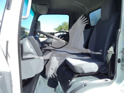 Isuzu NPR HD cab interior showing driver seat and steering wheel in right-side view with dashboard and passenger seat.