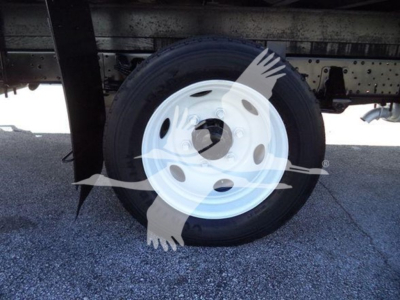 Isuzu NPR HD truck wheel and undercarriage view showing front wheel with white steel rim and tire.
