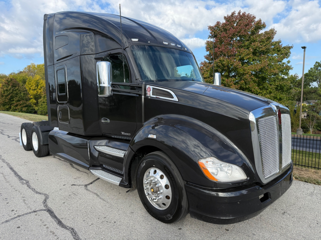 Kenworth T680 truck in black viewed from front-left showing tractor cab with chrome mirrors and grille.