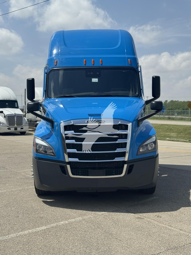 Front view of a blue 2023 Freightliner Cascadia 126 conventional sleeper truck with chrome grille, black bumper, and large side mirrors.