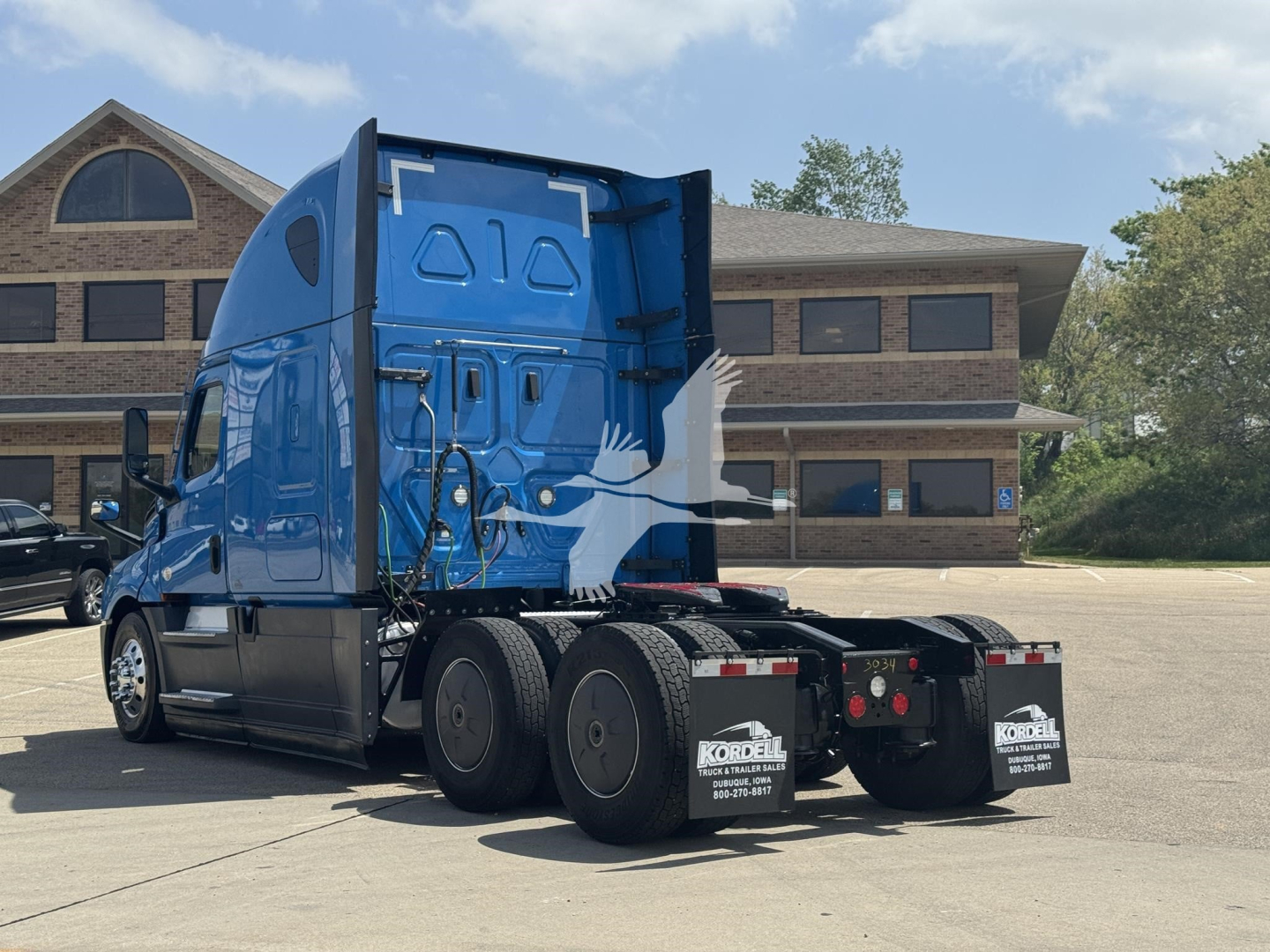 2023 Freightliner Cascadia 126 sleeper tractor rear and side view showing blue cab, dual rear axles, and fifth-wheel area.