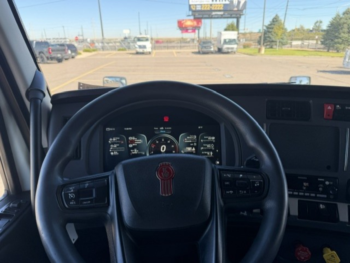 Kenworth T680 dashboard view from driver seat showing steering wheel and instrument cluster.