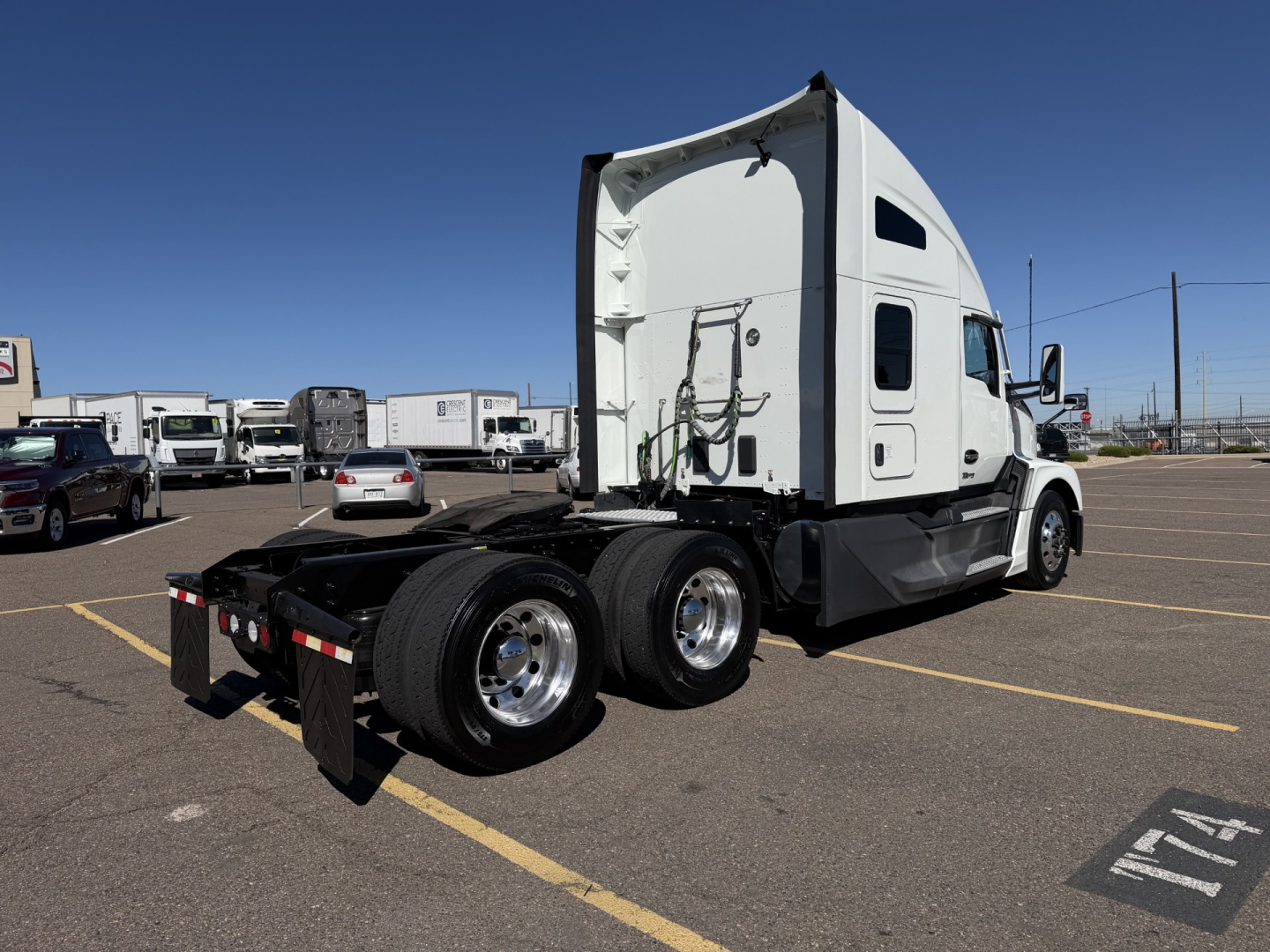 Kenworth T680 rear view showing cab, dual rear axles, and fifth wheel in a parking lot.