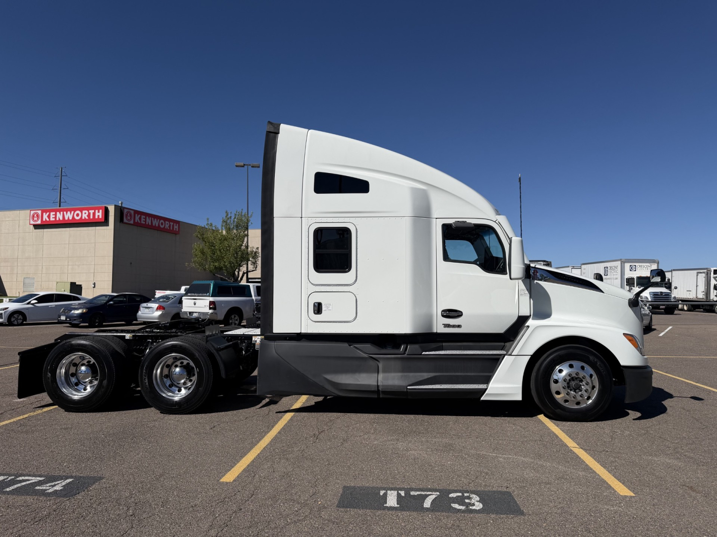 Kenworth T680 tractor side profile showing sleeper cab and chassis in parking lot.