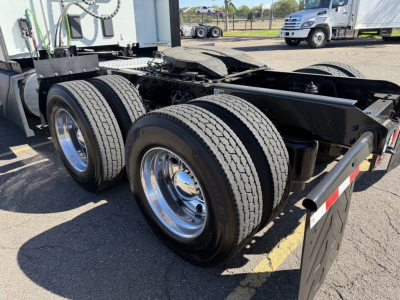 Kenworth T680 chassis rear view showing dual rear axles and fifth wheel with aluminum wheels and tires.