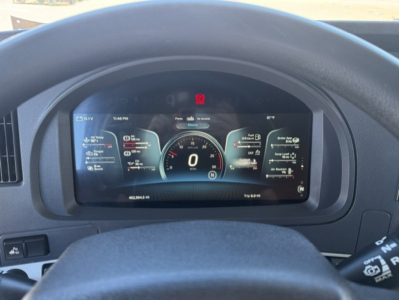 Kenworth T680 interior dashboard display showing digital gauges and speedometer in the center with surrounding data readouts.