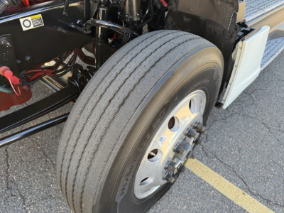 Kenworth truck front wheel and suspension detail showing tire, rim, and axle area