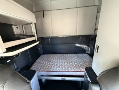 Kenworth T680 sleeper cab interior with bed and storage compartments visible.
