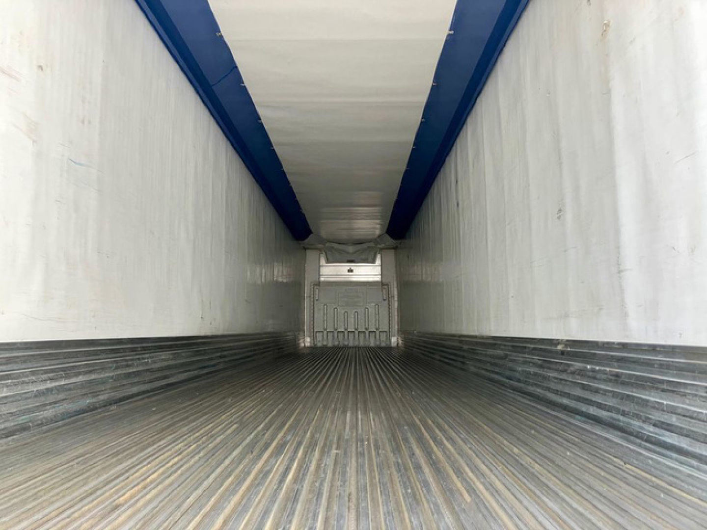 Trailer interior of a 2017 Utility Reefer showing ribbed metal floor and refrigerated walls with blue ceiling rails.