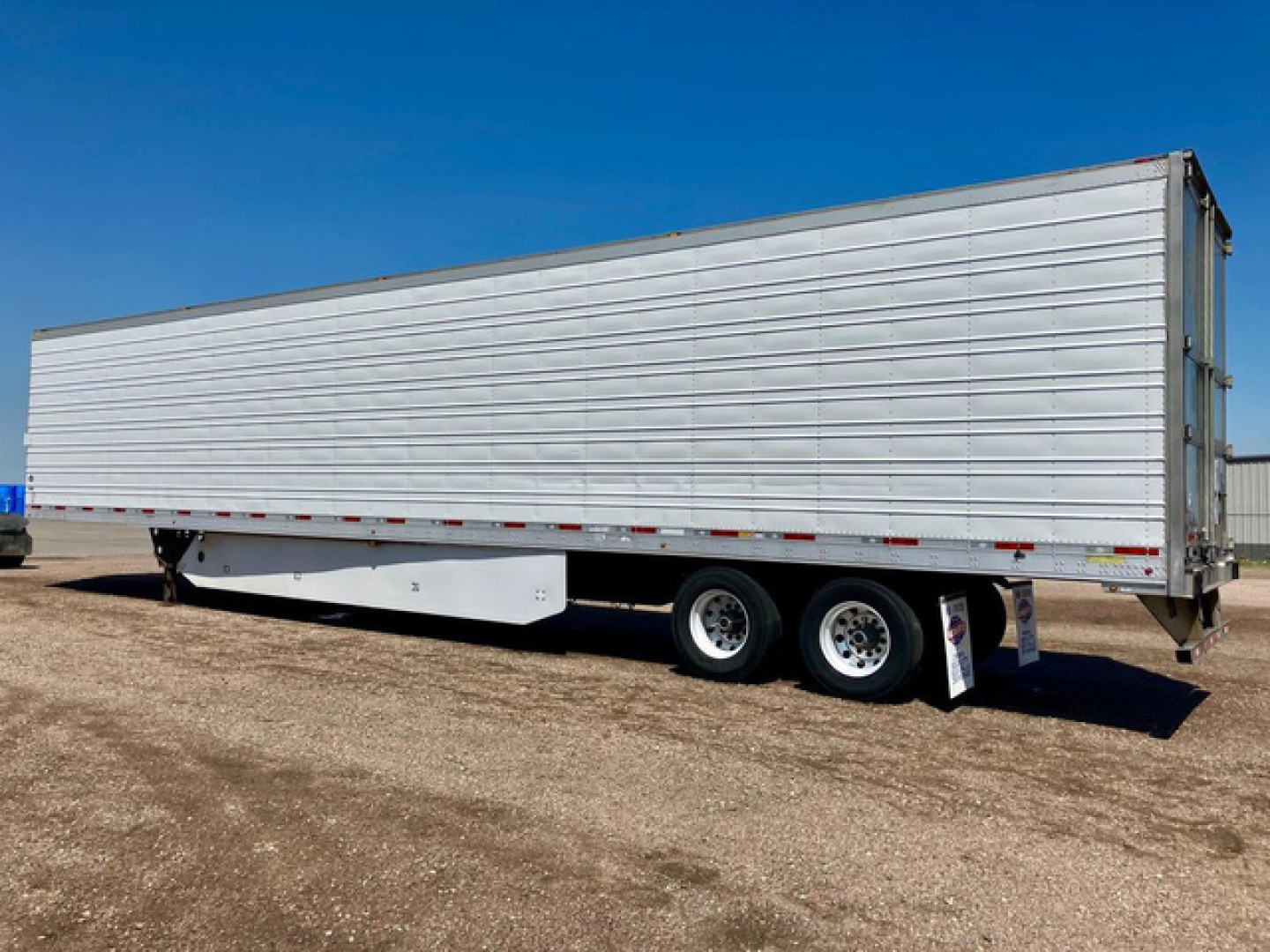 Trailer side view showing a 2017 Utility refrigerated trailer with metal siding and dual rear axles.