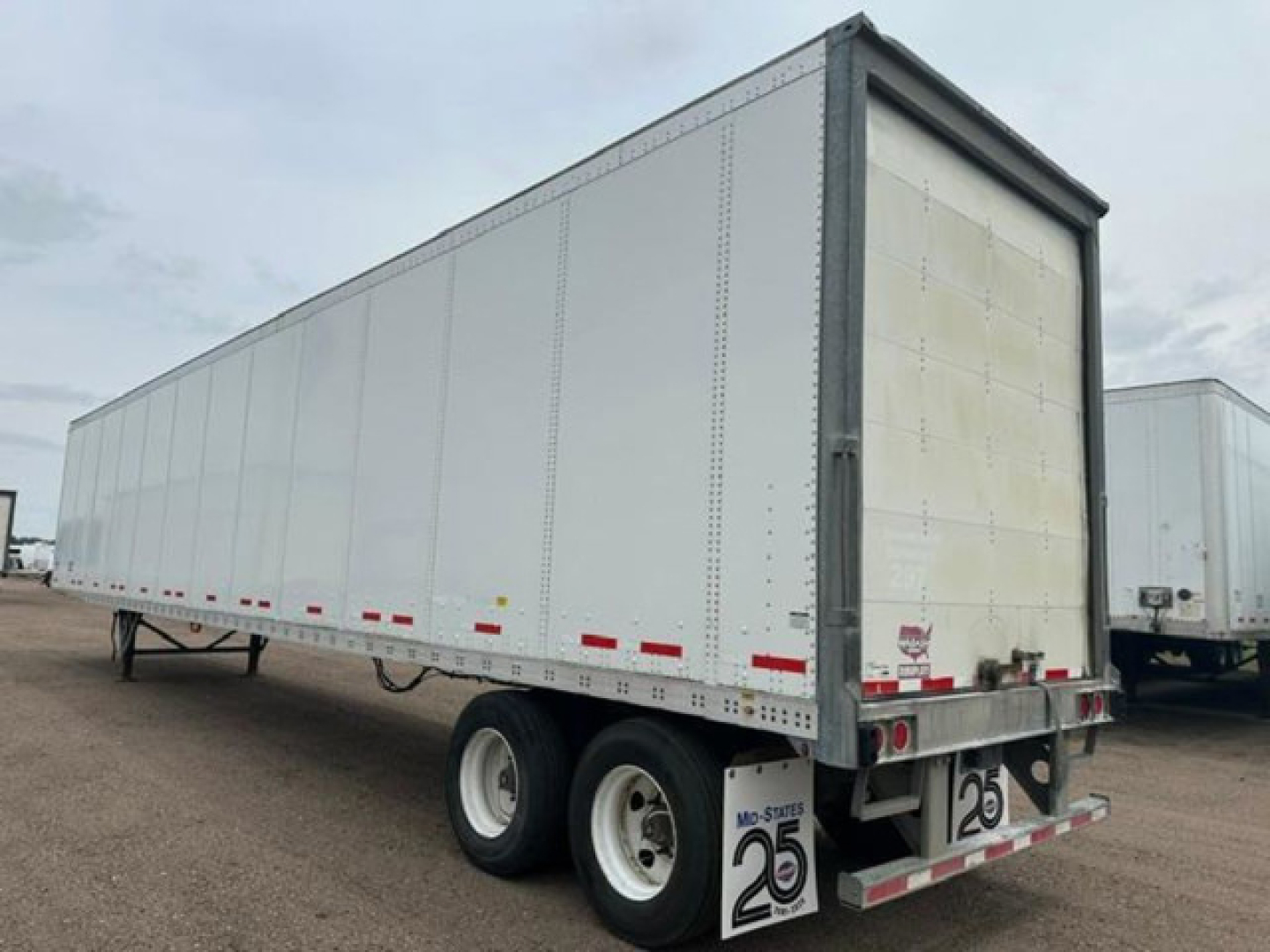 Trailer side and rear showing Wabash van trailer with dual rear axles and back doors.