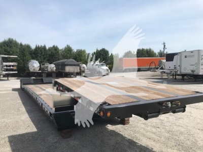 Lowboy trailer showing flat deck with wooden boards and black steel frame, rear lights, and extendable neck area.