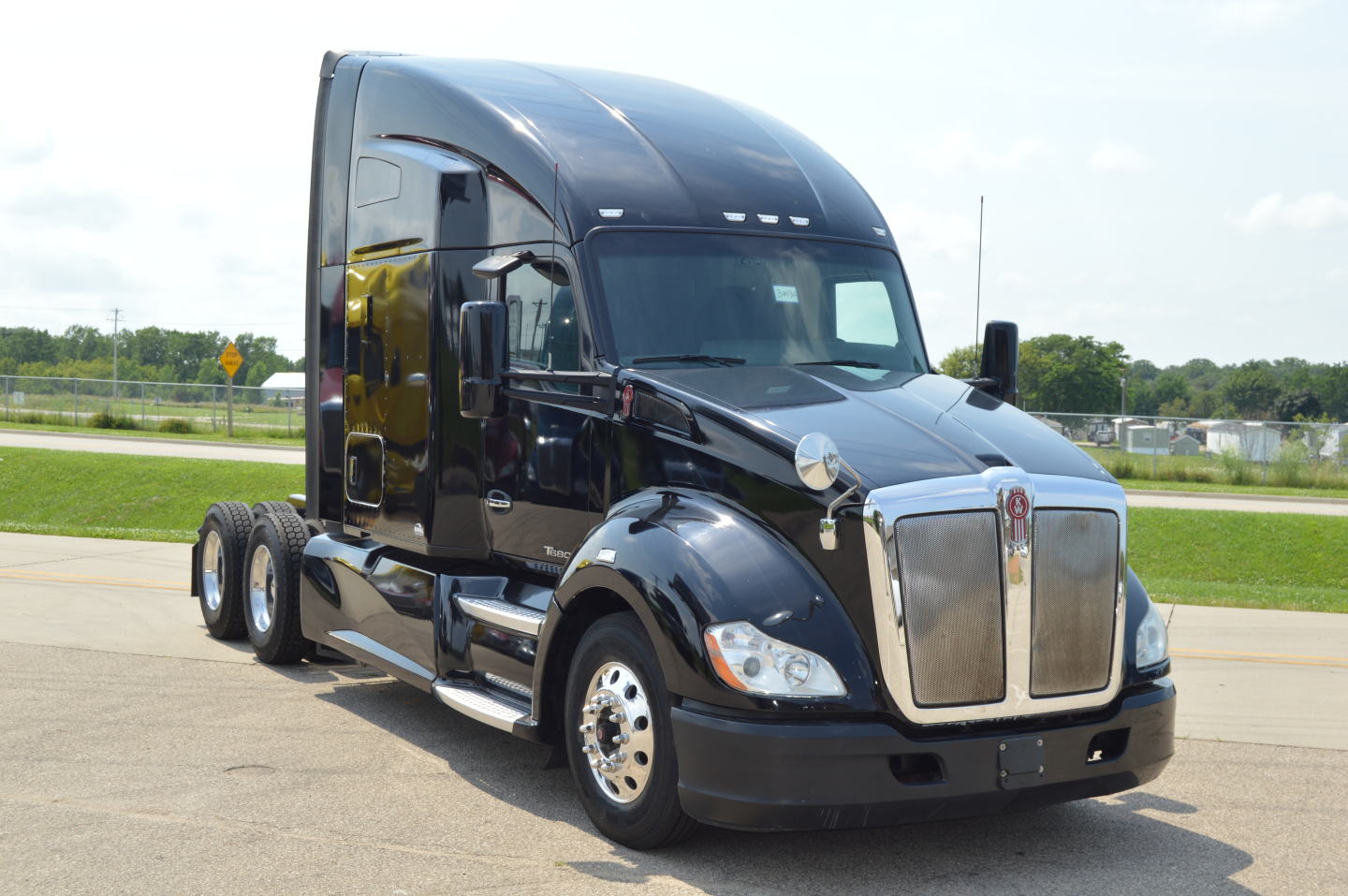 Kenworth T680 tractor-trailer cab in-profile view with glossy black paint and chrome grille, 2019 model year.