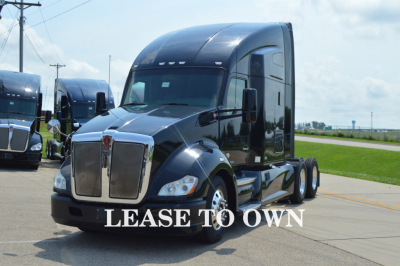 Kenworth T680 semi-truck front view in showroom lot with LEASE TO OWN text overlay
