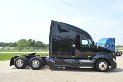 Kenworth T680 tractor in profile showing black sleeper cab with chrome wheels and dual rear axles.