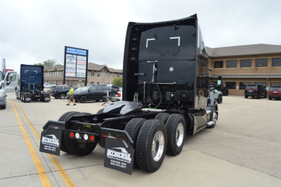 Kenworth T680 tractor unit rear view with fifth wheel and dual rear axles, cab back, wheels, and mud flaps.