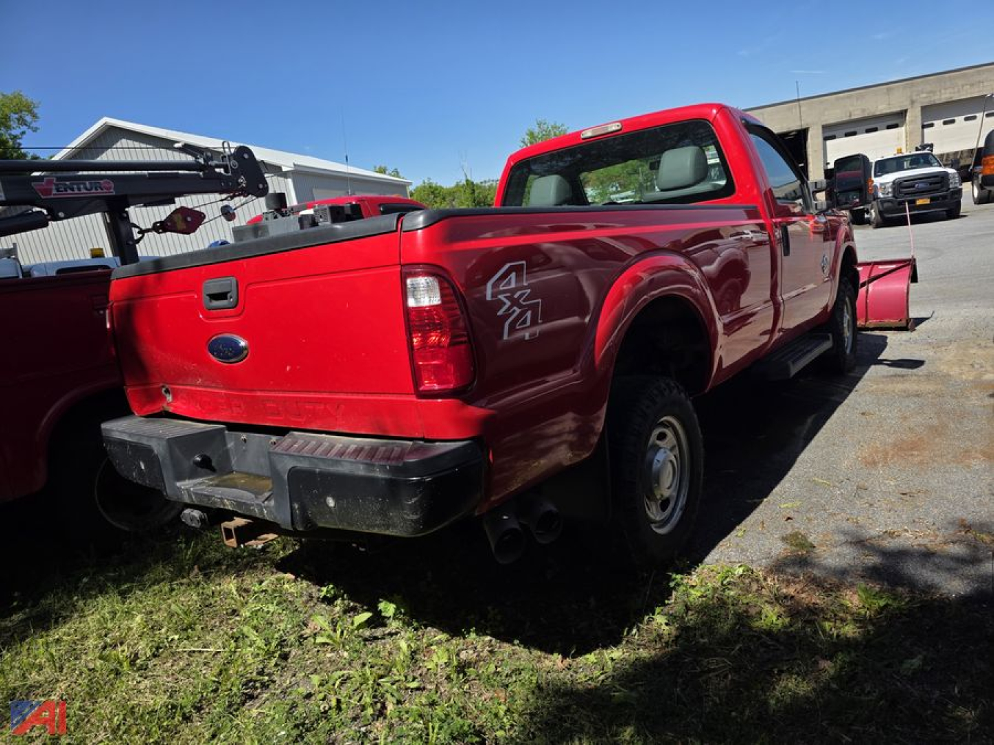 Ford F-350 Super Duty pickup truck in red with 4x4 badge and plow attachment, rear view showing tailgate and bumper.
