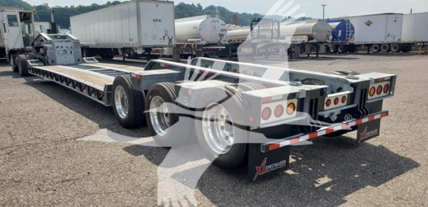 Trailer rear view showing a 55-ton lowboy trailer with 15 inch LDH galvanized deck and multiple axles.